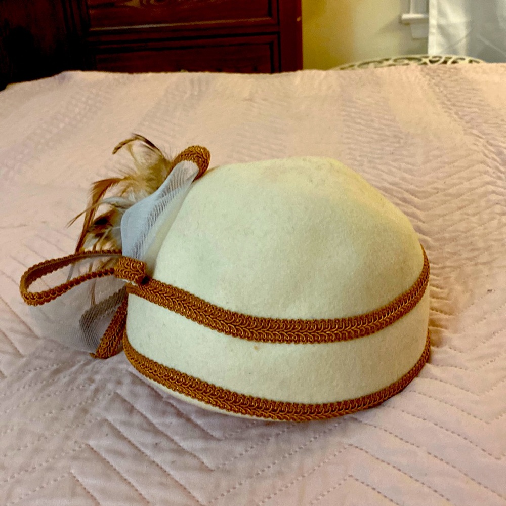 Feathered, cloche hat. Stylish cream hat.